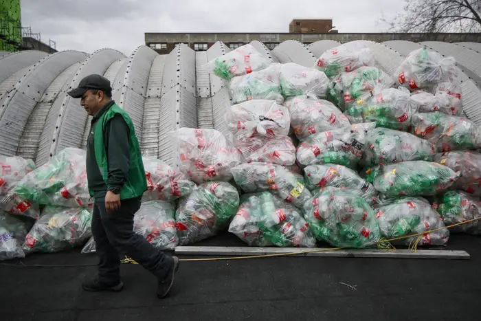 Manuel Rene Del Carmen organizes bags of recyclables on a roof at the Sure We Can, a Brooklyn non-profit redemption center.